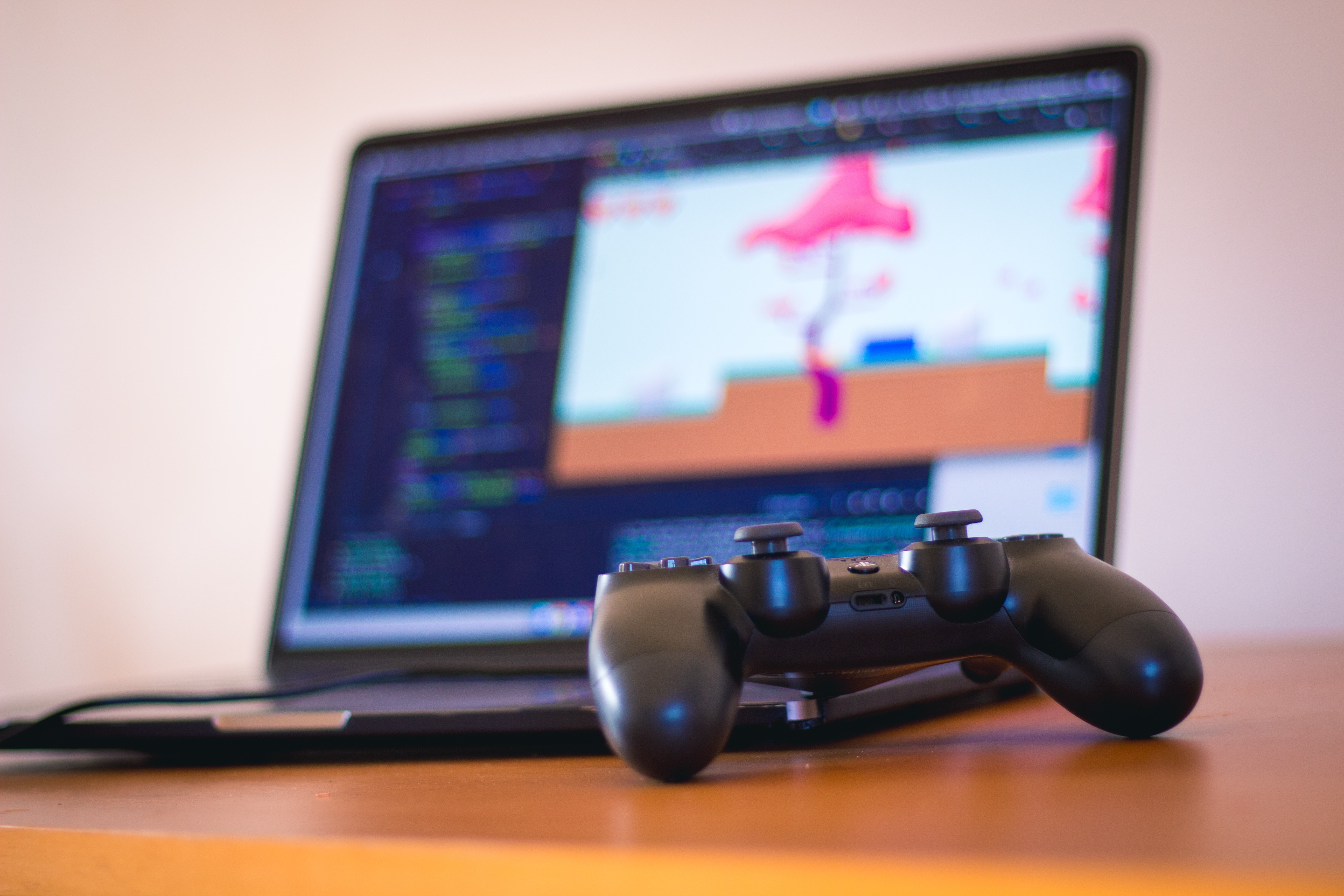 Playstation pad next to a laptop